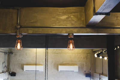 Illuminated pendant lights hanging from ceiling at home