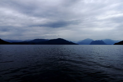 Scenic view of sea and mountains against sky