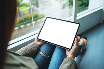 Midsection of woman using digital tablet