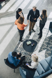 High angle view of male and female business colleagues greeting at conference