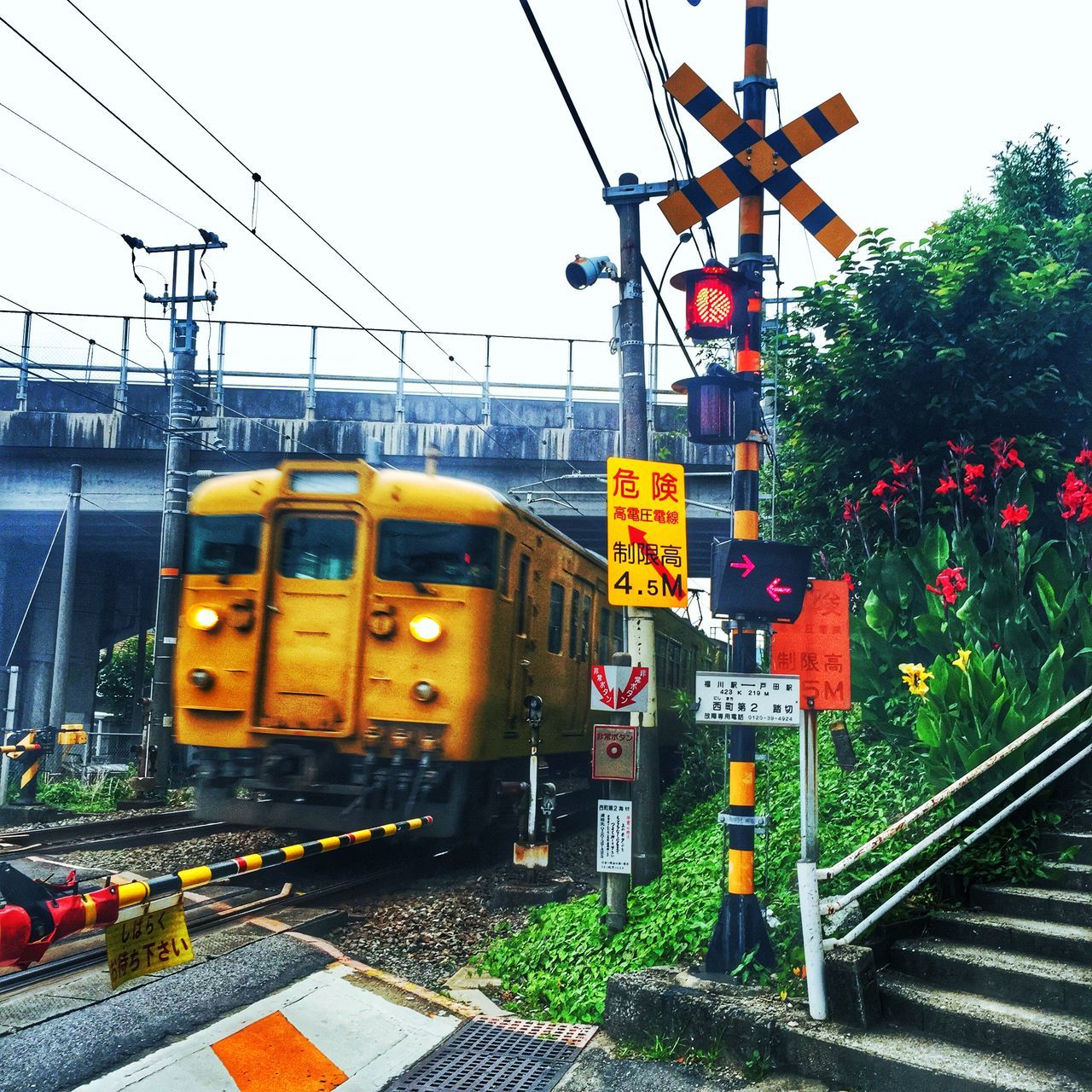 railroad track, rail transportation, transportation, public transportation, electricity pylon, power line, communication, railroad station, railroad station platform, text, train - vehicle, electricity, power supply, tree, guidance, sky, clear sky, fuel and power generation, connection, cable