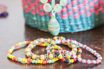 Close-up of colorful bracelets by basket on table