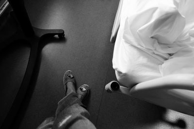 Low section of woman standing by bed in hospital