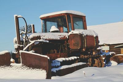 Abandoned truck on snow against clear sky