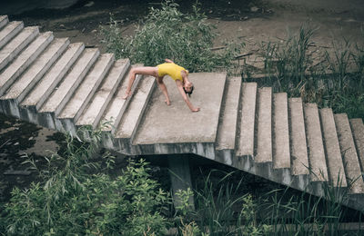 High angle view of young woman exercising on steps