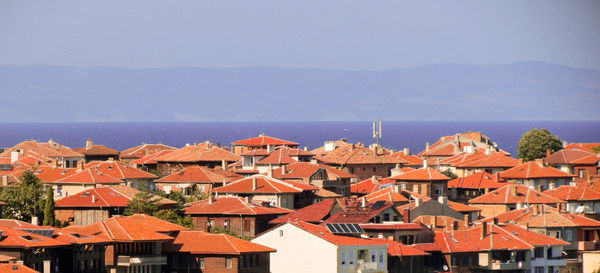 Residential district by sea against clear sky