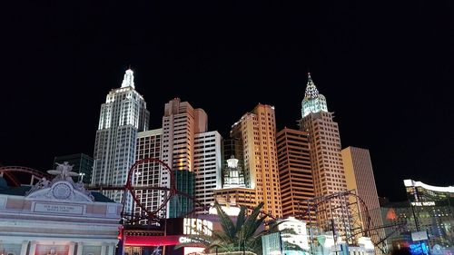 Low angle view of illuminated buildings against sky at night