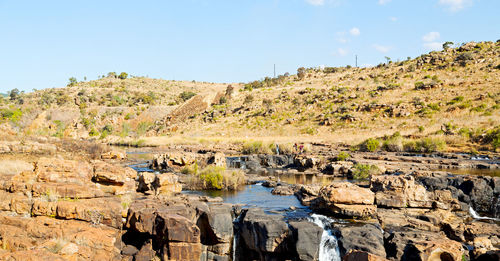 Panoramic view of rocks on shore against sky