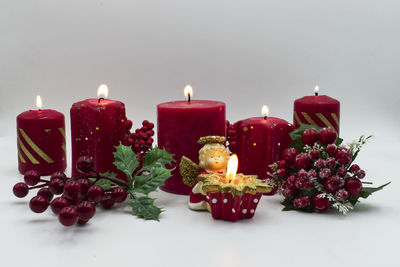 Close-up of multi colored candles against white background