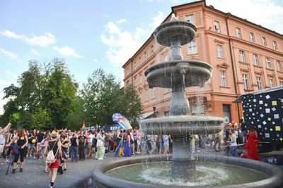 People at fountain in city