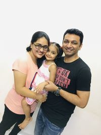 Portrait of happy friends standing against white background