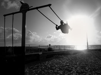 Low angle view of silhouette man in sea against sky