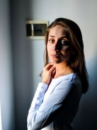 Portrait of woman standing against wall