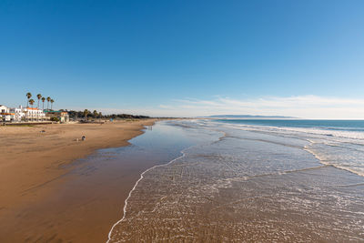 Scenic view of beach against blue sky