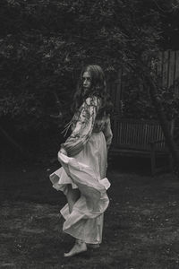 Woman standing by tree on land