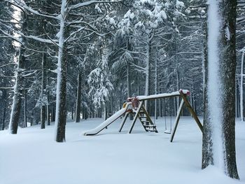 Snow covered swing in winter