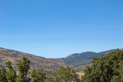 Scenic view of mountains against clear blue sky