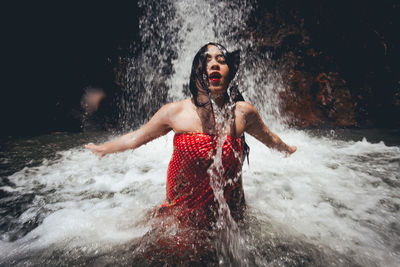 Young woman enjoying waterfall