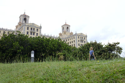 Rear view of building on field against sky