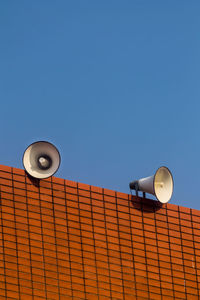 Low angle view of electric lamp against clear blue sky