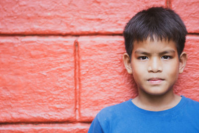 Close-up portrait of boy against wall