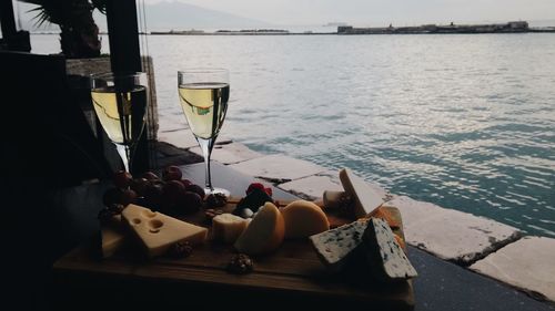 Close-up of fresh food and white wine by sea