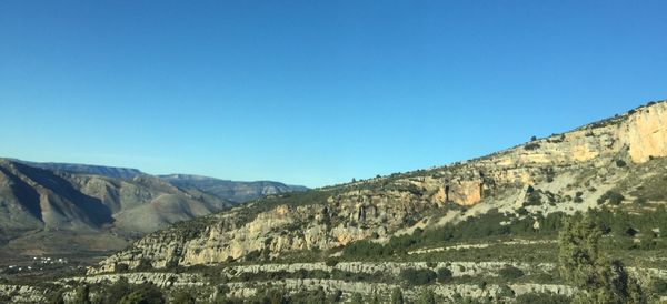 Low angle view of mountains against clear blue sky