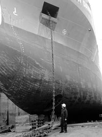 Rear view of man watching the anchor chain