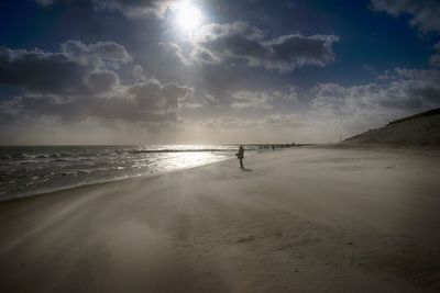 Silhouette person on beach against sky