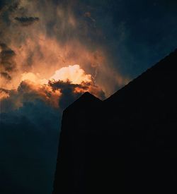 Low angle view of silhouette built structures against sky at sunset