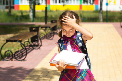 Happy girl holding a smiling while standing against blurred background