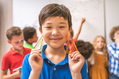 Portrait of cute boy holding ruler in classroom