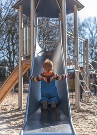 Rear view of boy sitting in park
