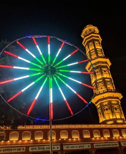 Low angle view of illuminated ferris wheel at night