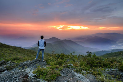 Rear view of man looking at sunset