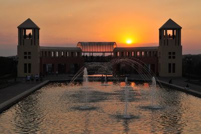 View of buildings at waterfront during sunset