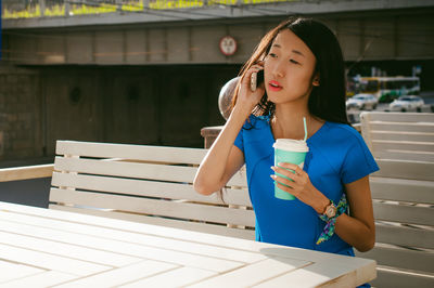 Woman having drink at sidewalk cafe