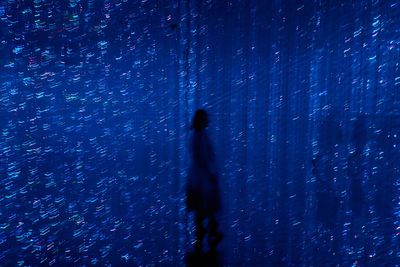 Silhouette person standing against blue sky during winter