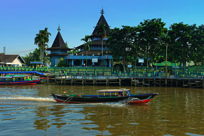 Boats moored in river against sky