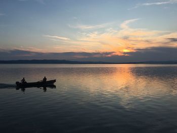 Silhouette boat in sea against sky during sunset