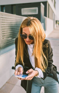 Woman using mobile phone in city