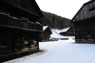 Snow covered houses and trees against sky