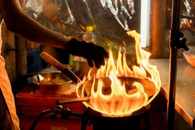 Midsection of chef preparing food in commercial kitchen