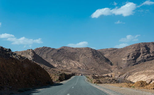 Road amidst mountains against sky