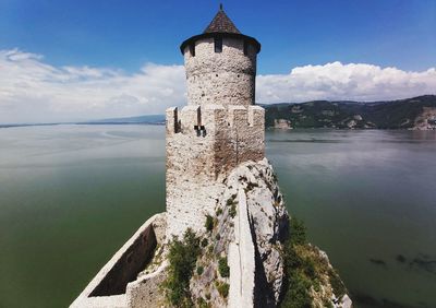 Castle by river against sky