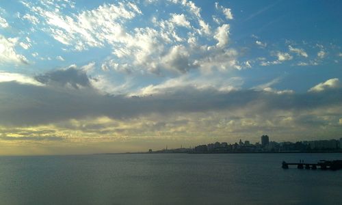 Scenic view of sea and cityscape against sky