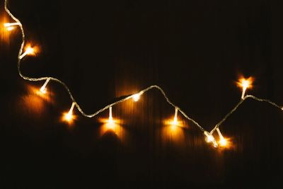 Close-up of illuminated lighting against sky at night