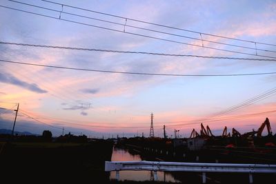 Silhouette bridge over calm sea at sunset