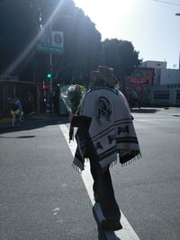 Rear view of man walking on road