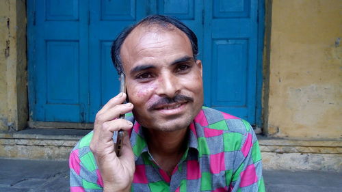 Smiling man talking on smart phone in city
